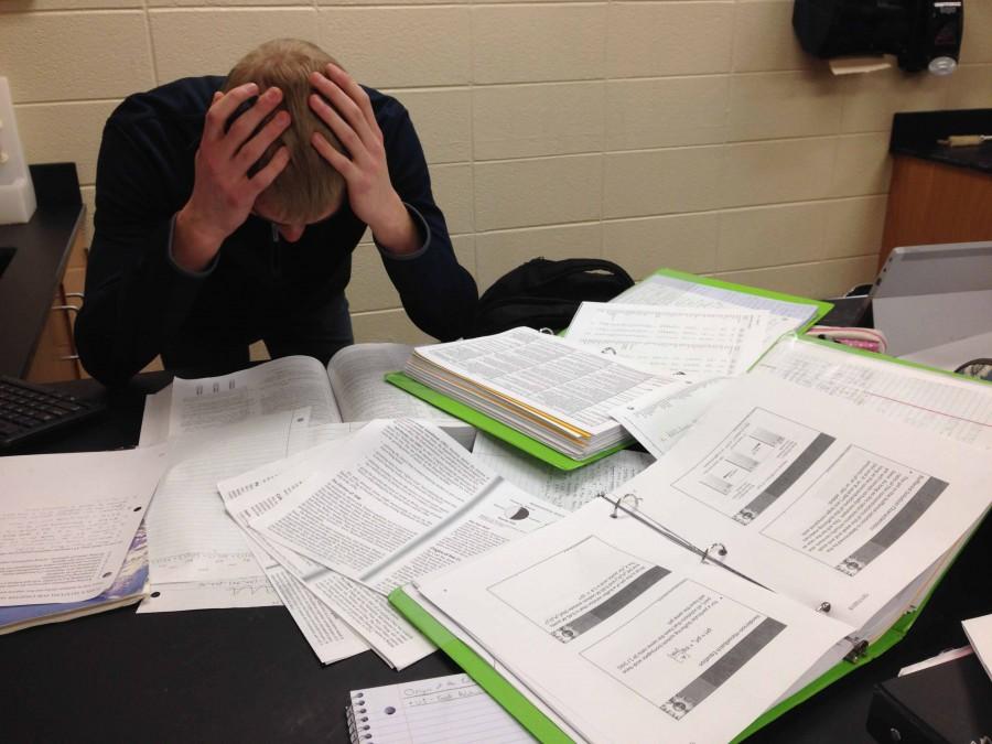 Michael Elwing (17) hunches over his AP Chemistry notes, problem sets, POGILS, and textbook as he tries to cram every ounce of knowledge about atoms, acid-base titrations, and the gas laws for the exam. 