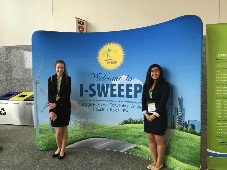 Reilly Olinger (18) and Laurel Cheng (18) stand in front in front of the I-SWEEP banner in Texas.
