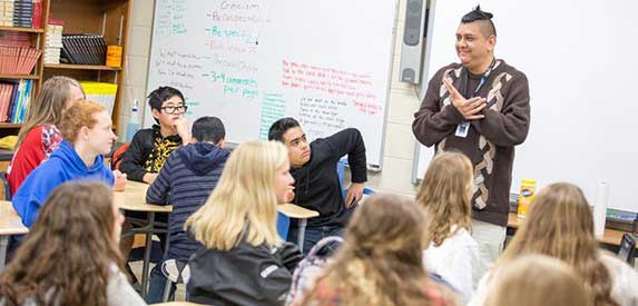 Mr. Lopez teaches his class of engaged English 9 Honors students.