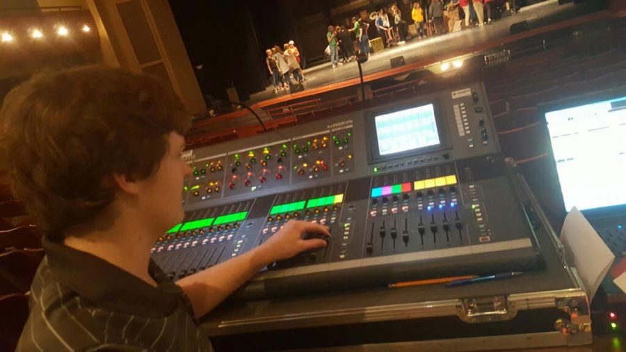 Gage Gosset (17), stage manager, manages the sound system during a dress rehearsal at the Wilson Center.