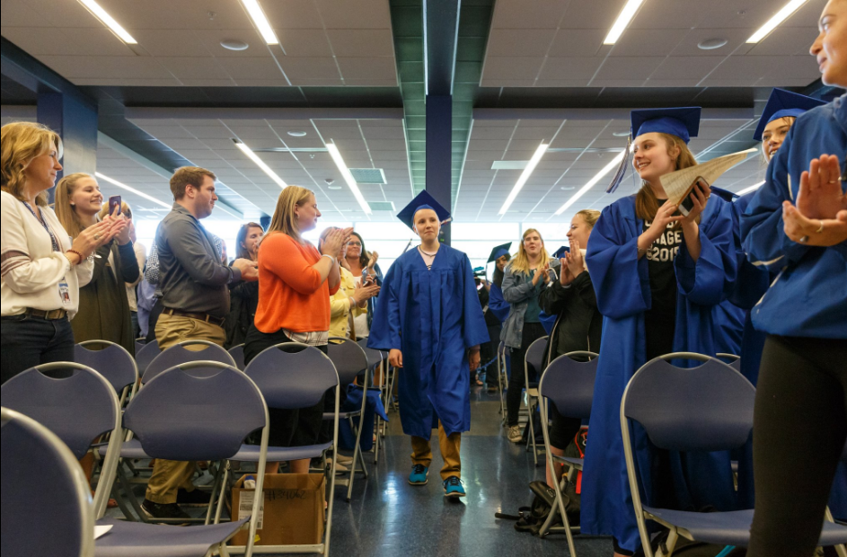 Andrew walks into the room as his diploma is presented.