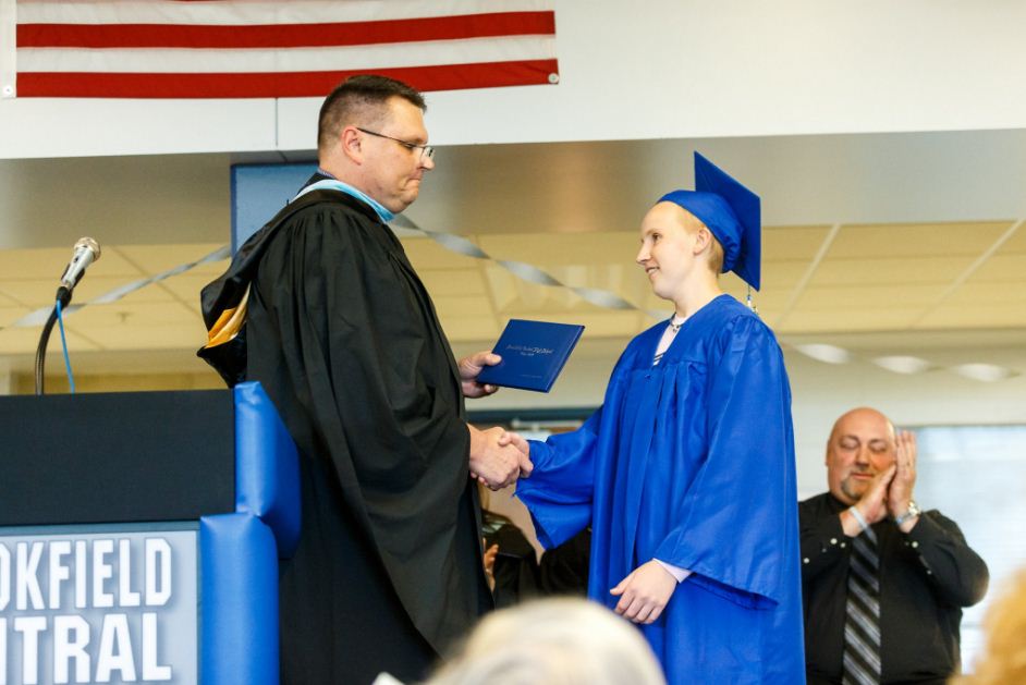 Andrew Wernicke and Principal Brett Gruetzmacher shake hands as Andrew receives his diploma.