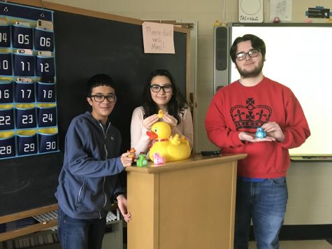 Liem Rao (23), Alana ONeill (23), and Kaya Shaw (22) smile with some ducks both off and new, with James Pond front and center on the podium. These three French 2 students, along with Megan Manganaro (23), Khalil Towns (23), and Alex Enaci (23), helped bring in the newest batch of rubber ducks. 