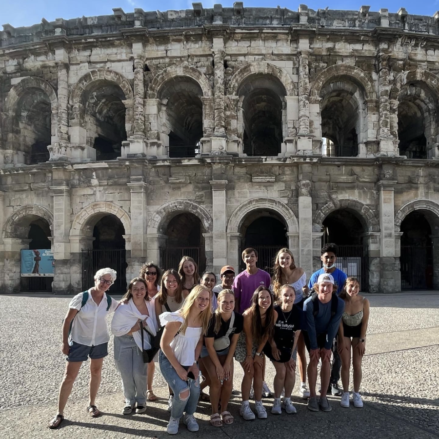 French trip students pose in front of an arena at Nîmes.